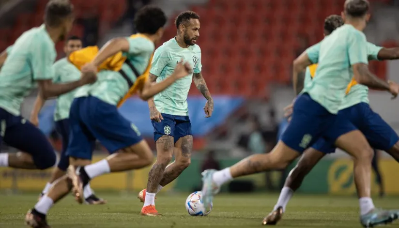 A foto mostra um treino do Brasil. Seis jogadores estão desfocados e Neymar está em foco, no centro da imagem.